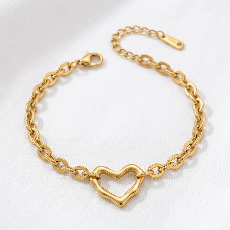 Gold chain bracelet with a heart-shaped clasp on a white background