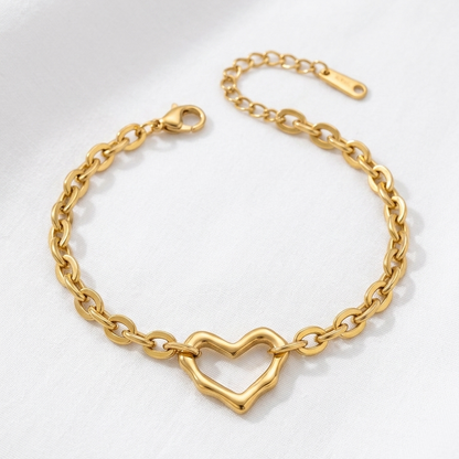 Gold chain bracelet with a heart-shaped clasp on a white background