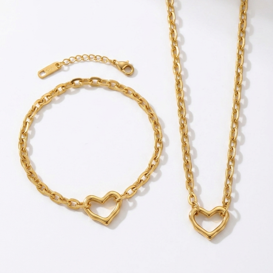 Gold heart-shaped bracelet and necklace set on a white background